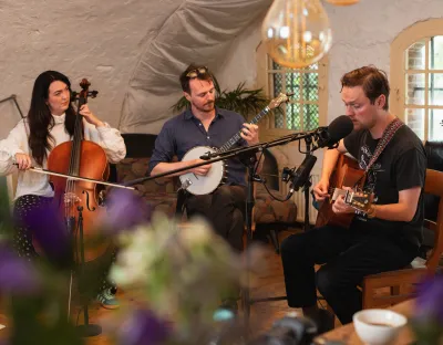 3 musicians playing cello, banjo, and guitar