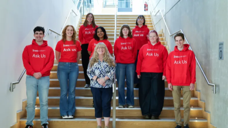 People in red sweatshirts standing on wooden staircase