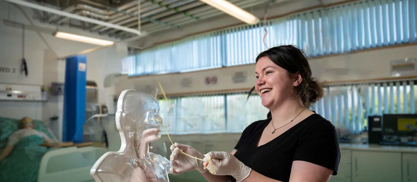 a woman performing a medical demonstration with a dummy