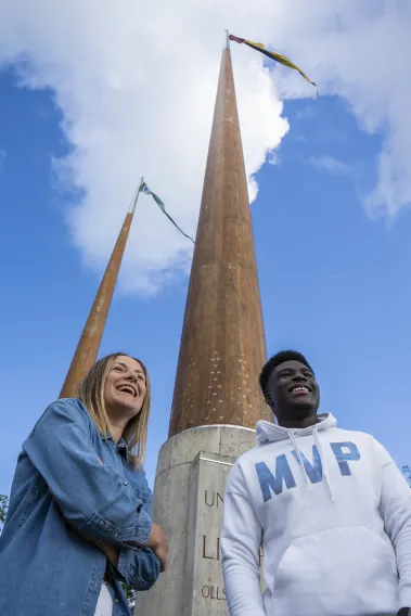 two UL students at flag poles on campus