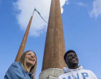 two UL students at flag poles on campus