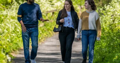 three students working through wooded area